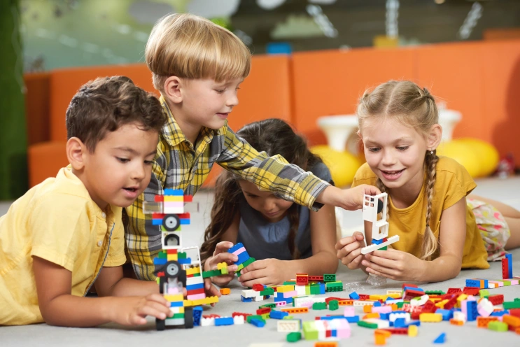 Children playing with blocks together, supporting social skill development in children with autism.