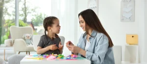 Therapist using antecedent strategies in ABA to support a child’s communication and learning through play.