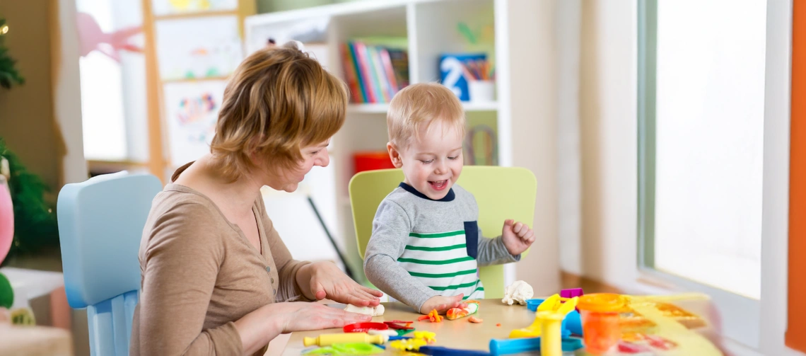 Parent and child enjoying sensory activities for kids autism at a table with colorful hands-on play materials.