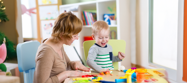 Parent and child enjoying sensory activities for kids autism at a table with colorful hands-on play materials.
