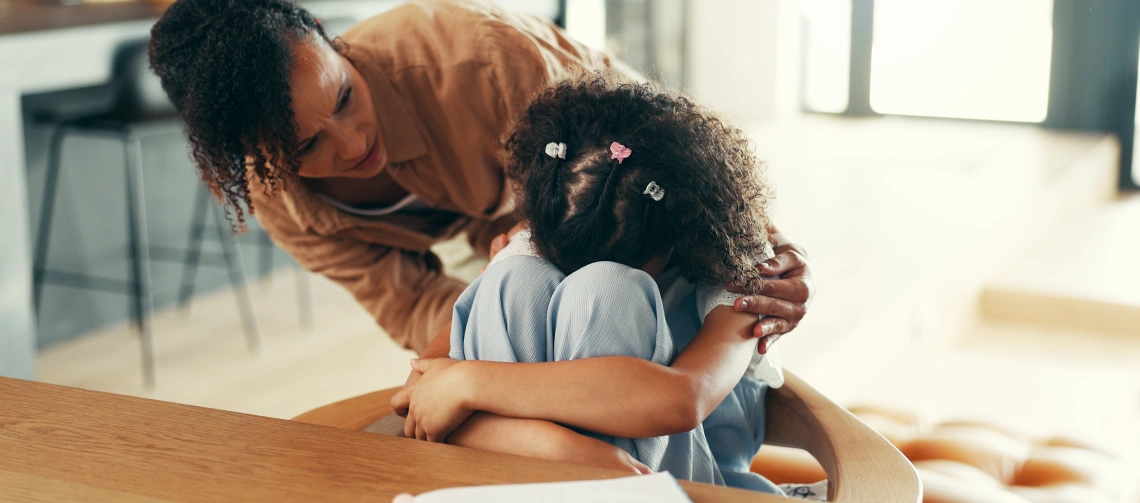 Parent using calming strategies for kids with autism by offering close, reassuring support during an overwhelming moment.