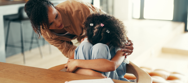 Parent using calming strategies for kids with autism by offering close, reassuring support during an overwhelming moment.